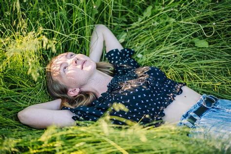 Portrait of a Young Girl Lying in the Green Grass on a Summer Day ...