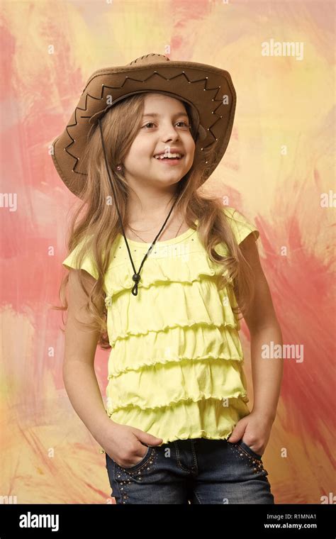 beautiful little girl in fashion cowboy hat has smiling happy face on colorful background Stock ...