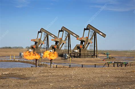 Gas flares and pumps at an oil field - Stock Image - C023/9313 ...