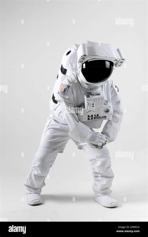 Astronaut stretching before exercise, white background Stock Photo - Alamy