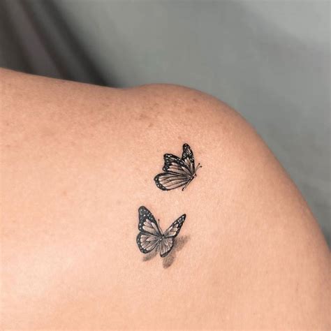 Fine line butterflies tattoo on the shoulder blade.