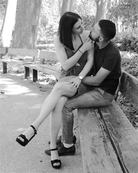 Young couple sitting on bench at park by Bruno Vilbé / 500px