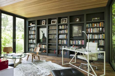 Built-in floor-to-ceiling bookshelves filled with Carnahan’s favorite titles create a library ...