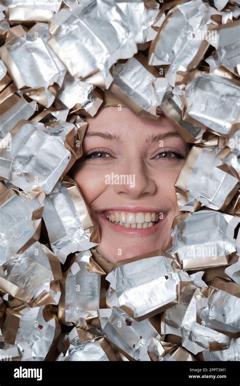 The face of a Caucasian woman surrounded by candy wrappers Stock Photo - Alamy