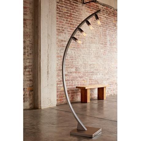 A retro industrial look defines this bronze finished floor lamp that includes four vintage style ...