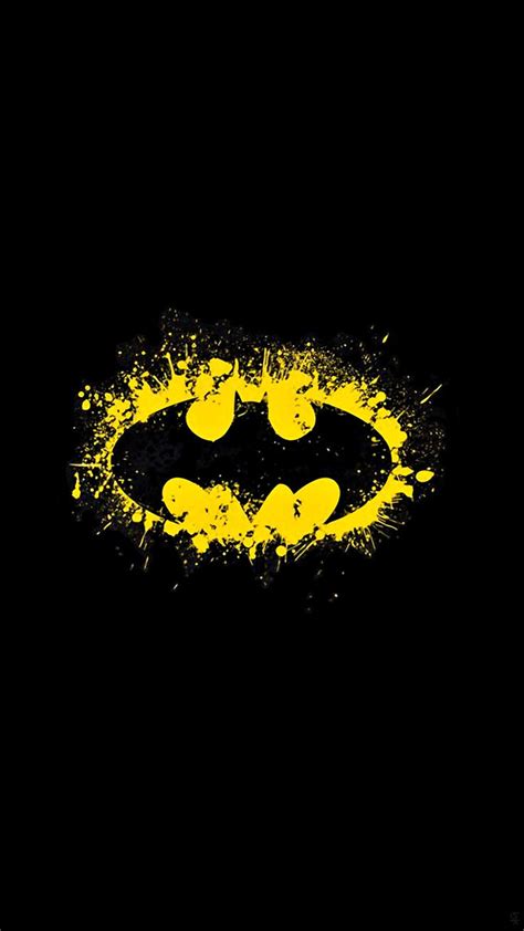 the batman symbol painted in yellow and black with paint splattered on it's face