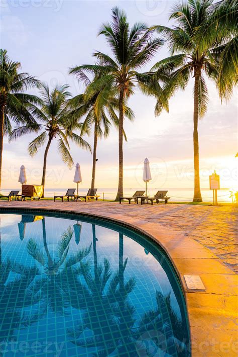 Umbrella and chair around swimming pool in hotel resort with sunrise in morning 15187687 Stock ...