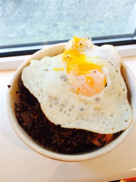 an egg on top of some sort of meat in a bowl next to a window