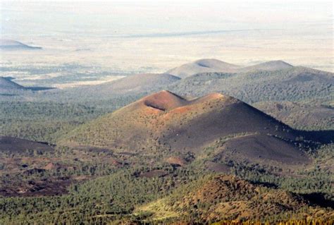 an aerial view of mountains and valleys in the distance with trees on ...