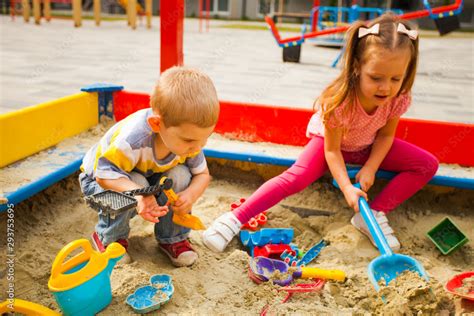 Adorable little kids playing in a sandbox Stock Photo | Adobe Stock