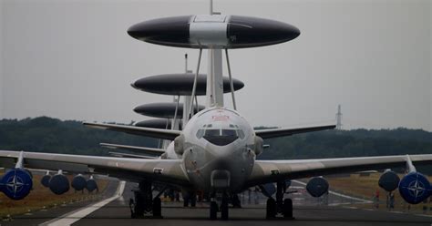 an airplane is sitting on the tarmac with its wheels down and people standing around it