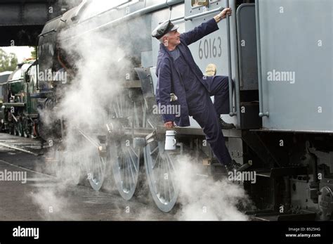 A steam engine driver climbs into his cab. The train is 60163 Tornado, on the Great Central ...