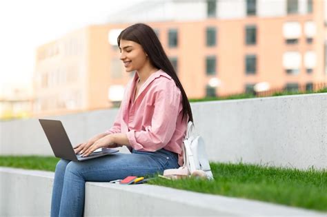 Premium Photo | Casual girl student working on laptop outdoors