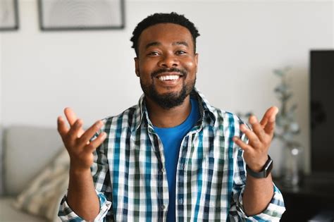 Premium Photo | Cheerful black man talking looking at camera sitting at home