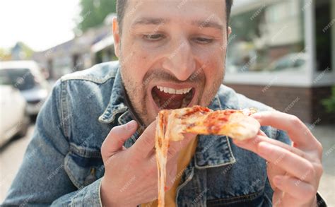 Premium Photo | A man eating a slice of pizza