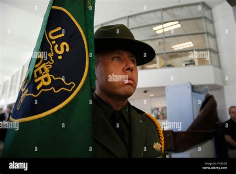 A U.S. Border Patrol agent carries the Border Patrol flag into a ...
