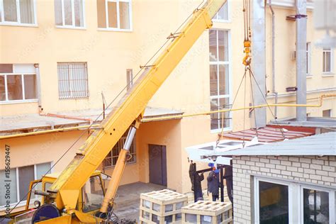 Industrial crane operating and lifting heavy object Stock Photo | Adobe Stock