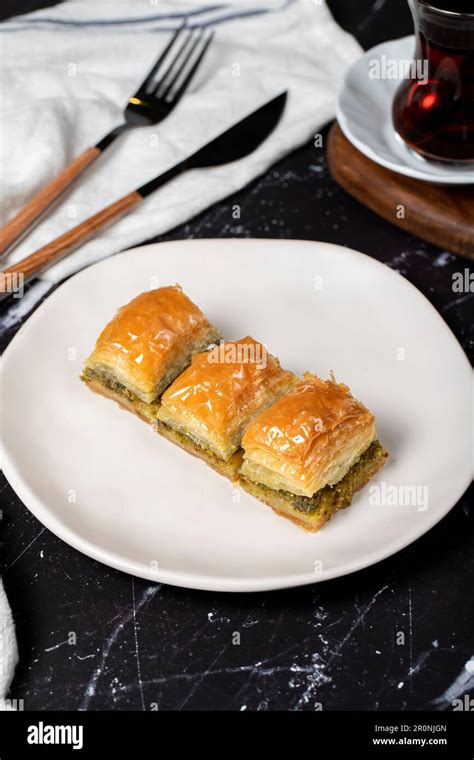 Pistachio baklava. Pistachio baklava with syrup on a dark background. Turkish cuisine delicacies ...