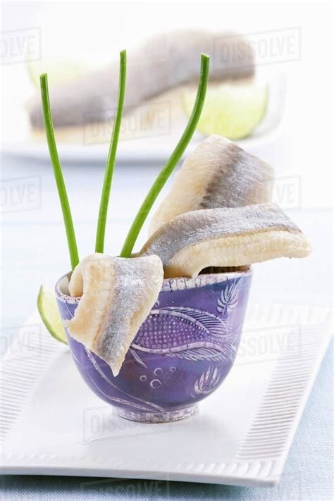 Soused herring fillets in a blue cup - Stock Photo - Dissolve