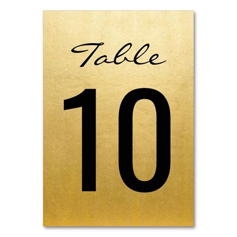 a gold table number sign with the word table 10 written on it in black ink