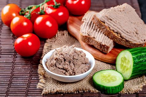 Delicious pate in a bowl and on sandwiches on the table with tomatoes and cucumbers - Creative ...
