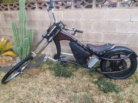 a motorcycle parked in front of a brick wall next to a green cactus and ...