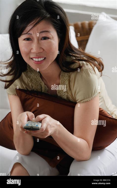 Woman holding TV remote control Stock Photo - Alamy
