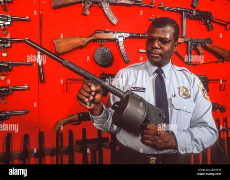 WASHINGTON, DC, USA - Police officer holds gun in front of display of ...