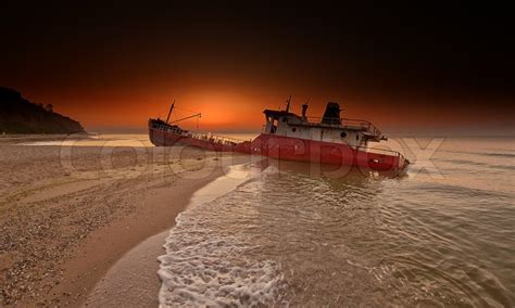 Abandoned broken ship-wreck beached on rocky sea shore. | Stock Photo | Colourbox