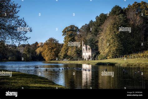 Autumn reflection of the abbey ruins in Painshill Park, Cobham, Surrey ...