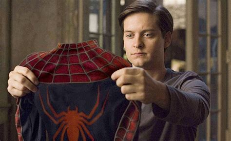 Download Tobey Maguire Holding Spider Man Suit Wallpaper | Wallpapers.com