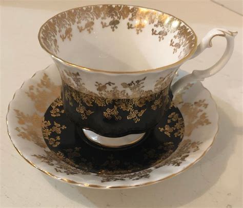 a black and gold tea cup on a saucer