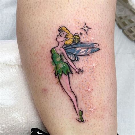 a woman's leg with a small tattoo of a tinkerbell on it