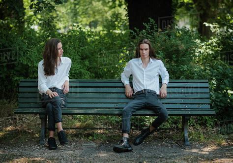 Multiple image man sitting on park bench with legs crossed and legs ...