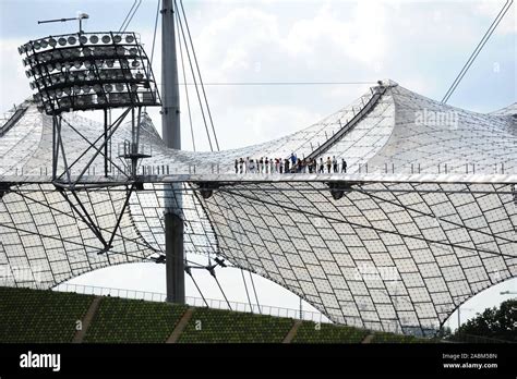 Stadium visitors on a tour on the tent roof of the Munich Olympic ...