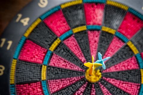 Two Darts pinned in Bullseye of a Colorful Plastic Toy Dart Board - Creative Commons Bilder