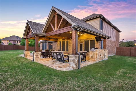 Double gable patio cover with outdoor kitchen and flagstone flooring ...