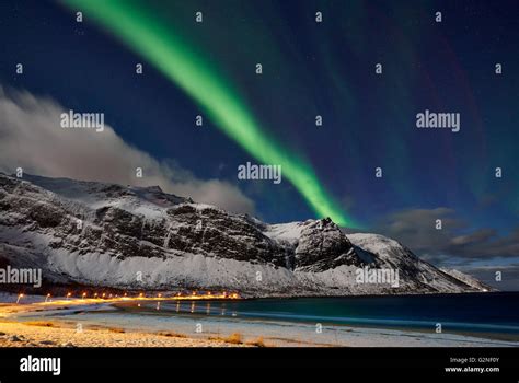 Aurora Borealis or northern lights over winter landscape in fjord of Ersfjorden, Senja, Troms ...