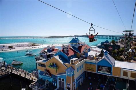 an aerial view of some buildings and boats in the water with a person on a ski lift above them