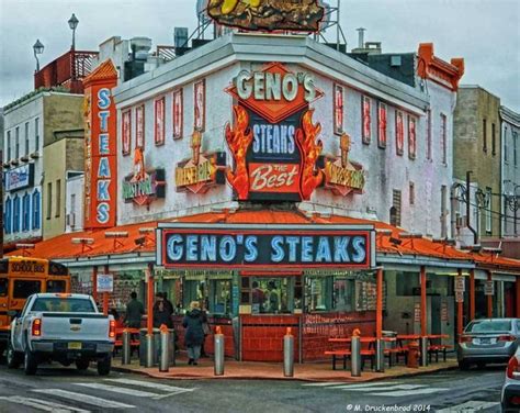 the geno's steaks restaurant is painted orange and has neon signs on it