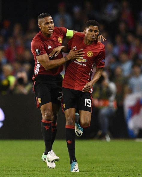 two soccer players are hugging each other on the field