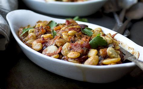 Lima beans are baked in a savory tomato sauce with vegetables, thyme, and oregano, and topped ...