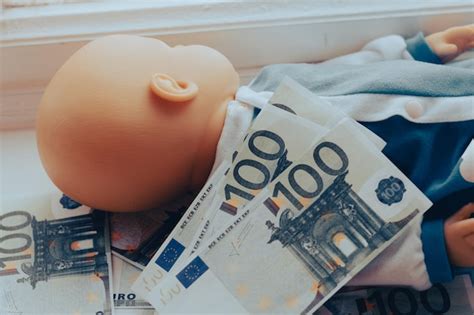 Premium Photo | Baby doll lies with euro money children sale concept