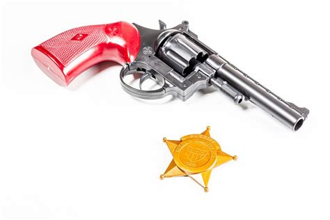 Toy gun with police badge on white background - Creative Commons Bilder