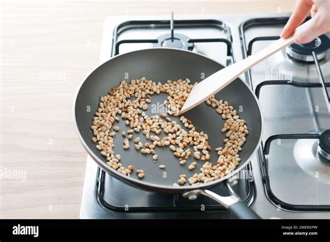 Toasting pine nuts Stock Photo - Alamy