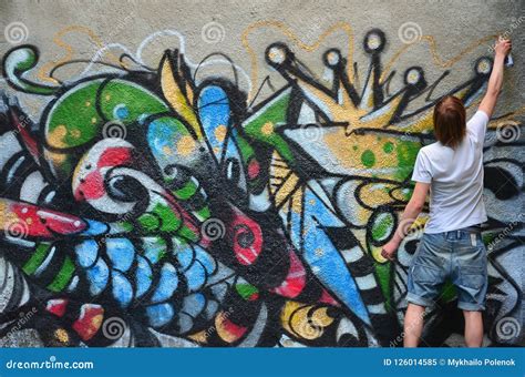 The Guy Draws on the Graffiti Wall a Drawing with Aerosol Paints of Various Colors Stock Image ...