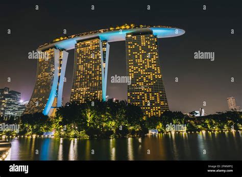 Marina Bay Sands Singapore hotel by the river illuminated at night time ...