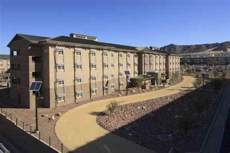 an apartment building in the desert with mountains in the background