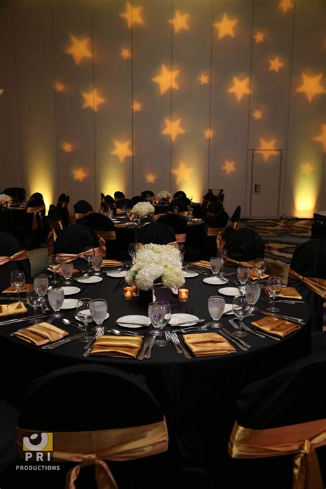 Custom star Gobo lighting projected on a wall during an awards ceremony. Black and gold color ...