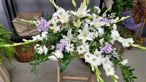 An incredible casket spray with white lilies, purple stock, and more by Field's Floral and Gift ...